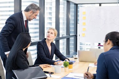 Businessman explaining new business ideas to peers in conference room during meeting at office.