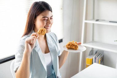 Young woman was happy to eat the delicious fried chicken. fried chicken drumstick