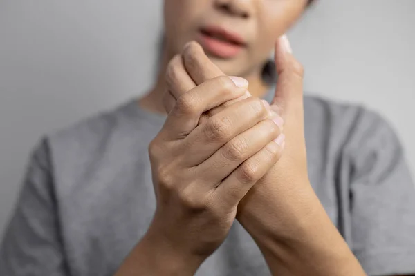 Woman suffering from pain in hand. Pain in the hand. Young woman hold pain of hand.