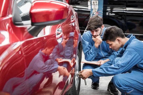 Two Auto Mechanic Doing Car Service Maintenance Wheel Mechanic Checking — стоковое фото