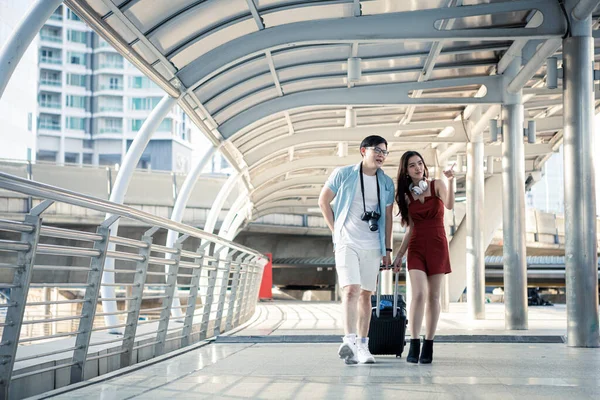 Fiatal Pár Egy Bőrönddel Boldogan Beszélgetnek Mosolyogva Miközben Városban Utaznak — Stock Fotó