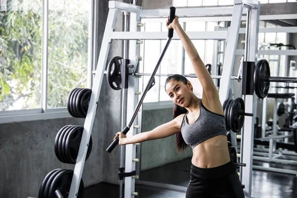 Attractive fit woman works out fitness in the modern gym.