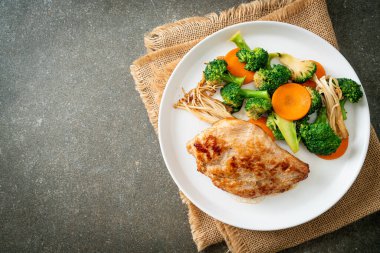 Beyaz tabakta sebzeli ızgara tavuk bifteği