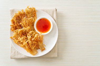 Kızarmış enoki mantarı ya da baharatlı soslu altın iğneli mantar - vejetaryen yemek tarzı.