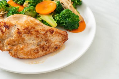 Beyaz tabakta sebzeli ızgara tavuk bifteği