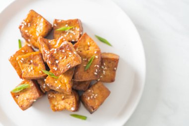 Beyaz susamlı kızarmış tofu ve teriyaki sosu. Vejetaryen ve vejetaryen yemek tarzı.