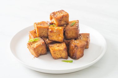 Beyaz susamlı kızarmış tofu ve teriyaki sosu. Vejetaryen ve vejetaryen yemek tarzı.