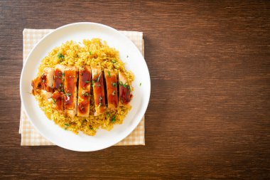 Izgara tatlı ve acılı tavuk ve tabakta körili pilav.