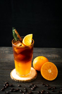 Bir bardak buzlu americano sade kahve ve biberiye ve tarçınla süslenmiş portakal ve limon suyu.