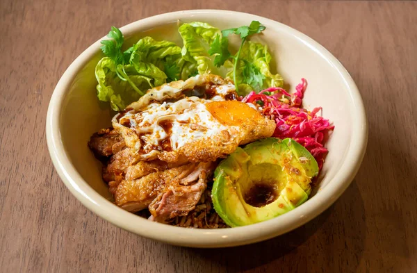 Kızarmış tavuk teriyaki soslu pilav ve avokado ve sahanda yumurta. Füzyon yiyecekler.