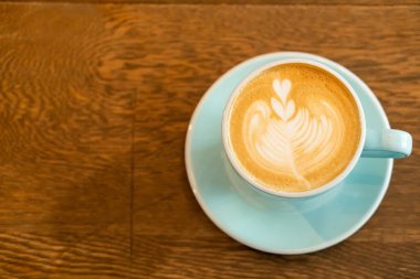 sıcak latte kahve fincanı ahşap masada.