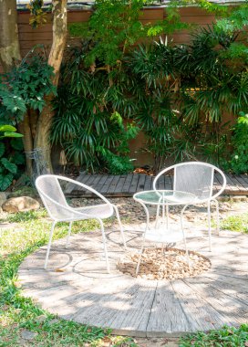 Bahçedeki boş beyaz sandalye.