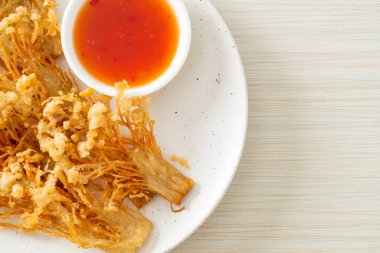 Kızarmış enoki mantarı ya da baharatlı soslu altın iğneli mantar - vejetaryen yemek tarzı.