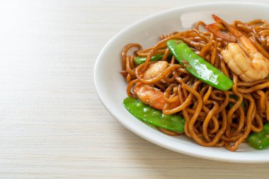 Kızarmış yakisoba eriştesi, yeşil bezelye ve karides, Asya usulü.