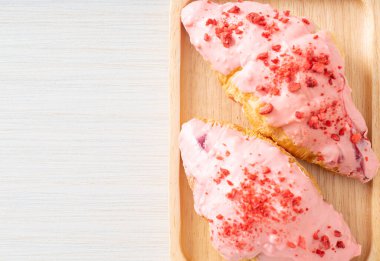 Tahta tabakta çilekli çikolata soslu kruvasan.