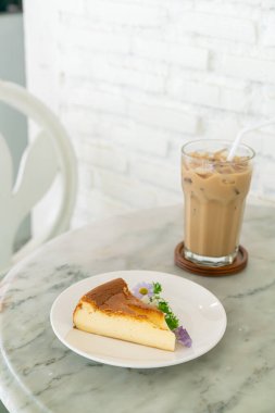 Bask Yanmış Cheesecake süslemesi. Beyaz tabakta çiçekler.