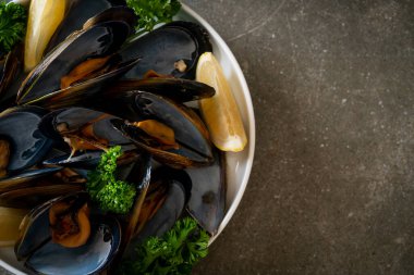 Limonlu bir kasede otlu taze midyeler.