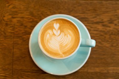 sıcak latte kahve fincanı ahşap masada.