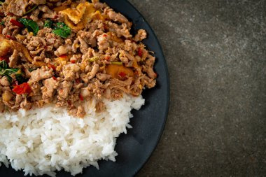 Pirinçli yumurta ve fesleğenli kızarmış domuz eti. Asya usulü.