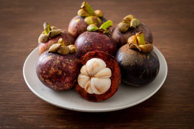 Taze taze mangosteen meyveleri beyaz tabakta