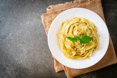 Pesto fettuccine makarna, üstüne de parmesan peyniri.