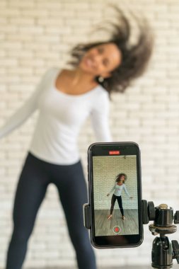 Latin kadın nüfuzlu kişi dans videosunu akıllı telefon kamerasıyla oluşturdu. Videoyu sosyal medya uygulamasına paylaşmak için.