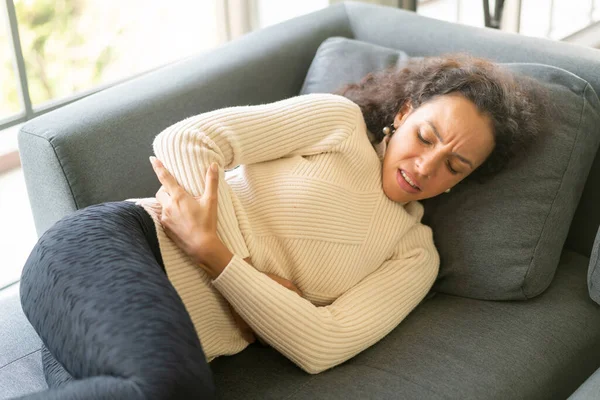 Wanita Latin Berbaring Sofa Rumah Dengan Perasaan Sakit Perut — Stok Foto