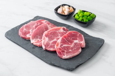 Taze domuz boyunlu ya da yakalı domuz eti ve terbiye edilecek malzemeler.