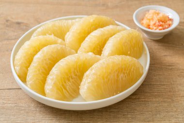 Taze soyulmuş zeytin, greyfurt ya da beyaz tabakta Shaddock.