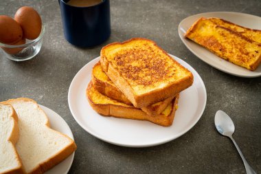 Kahvaltı için beyaz tabakta yumurtalı ekmek.