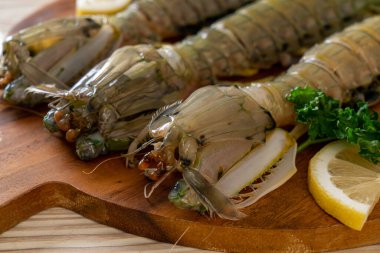 Tahtada limon olan taze peygamber devesi karidesi.