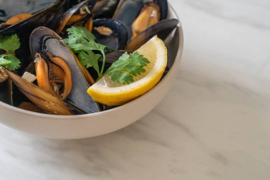 Limonlu bir kasede otlu taze midyeler.