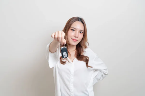 漂亮的亚洲女人拿着白色背景的车钥匙 — 图库照片
