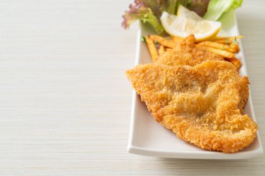 balık ve patates kızartması - kızarmış balık fileto patates cipsi ve limonlu beyaz tabak