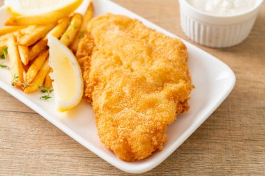 balık ve patates kızartması - kızarmış balık fileto patates cipsi ve limonlu beyaz tabak