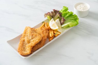 balık ve patates kızartması - kızarmış balık fileto patates cipsi ve limonlu beyaz tabak