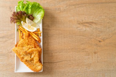 balık ve patates kızartması - kızarmış balık fileto patates cipsi ve limonlu beyaz tabak
