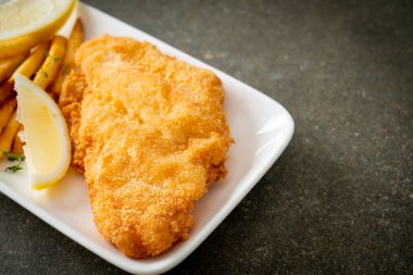 balık ve patates kızartması - kızarmış balık fileto patates cipsi ve limonlu beyaz tabak