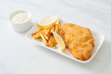 balık ve patates kızartması - kızarmış balık fileto patates cipsi ve limonlu beyaz tabak