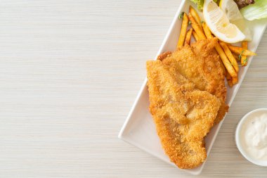 balık ve patates kızartması - kızarmış balık fileto patates cipsi ve limonlu beyaz tabak