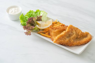 balık ve patates kızartması - kızarmış balık fileto patates cipsi ve limonlu beyaz tabak