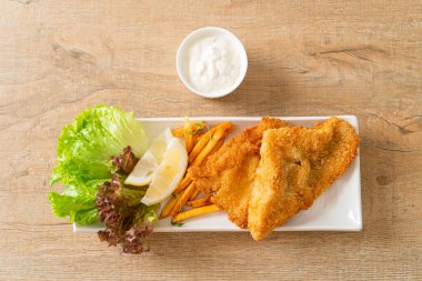 balık ve patates kızartması - kızarmış balık fileto patates cipsi ve limonlu beyaz tabak