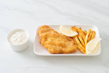 balık ve patates kızartması - kızarmış balık fileto patates cipsi ve limonlu beyaz tabak