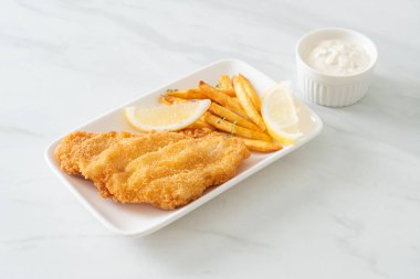 balık ve patates kızartması - kızarmış balık fileto patates cipsi ve limonlu beyaz tabak