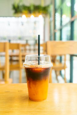 Kahve dükkanındaki masada portakal suyu bardaklı buzlu kahve.