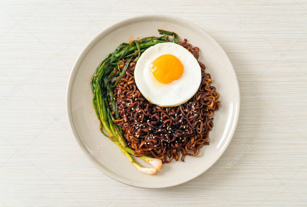 Homemade dried Korean spicy black sauce instant noodles with fried egg and kimchi