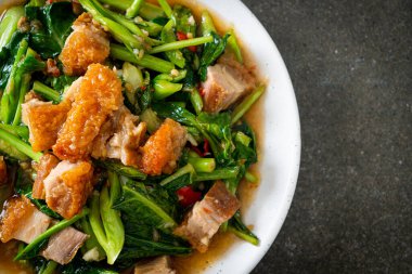 Kızarmış lahana sebzesi ve kıtır domuz eti Asya yemeği.