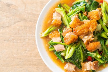 Kızarmış lahana sebzesi ve kıtır domuz eti Asya yemeği.