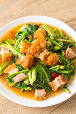 Kızarmış lahana sebzesi ve kıtır domuz eti Asya yemeği.