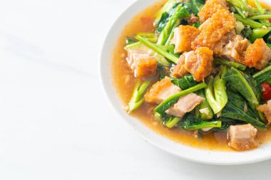 Kızarmış lahana sebzesi ve kıtır domuz eti Asya yemeği.